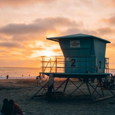 A lifeguard tower on the beach at sunset