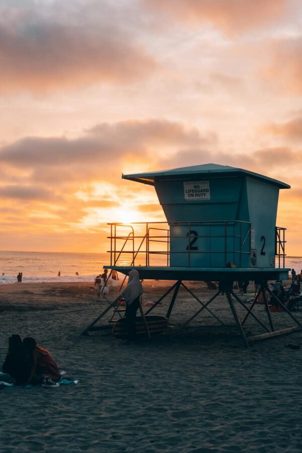 A lifeguard tower on the beach at sunset