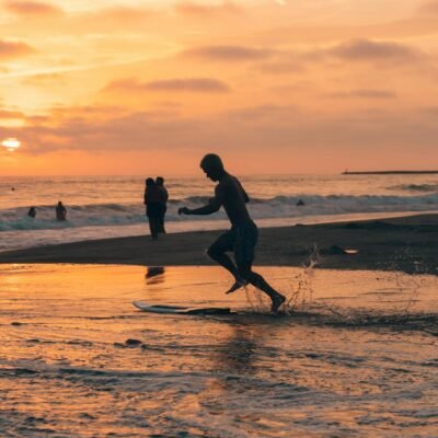 A man running on the beach at sunset