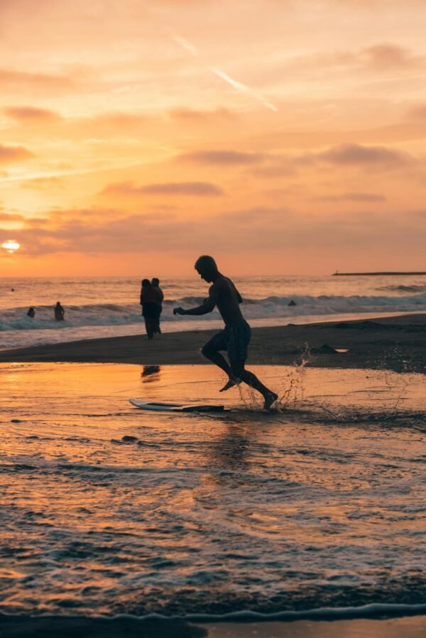 A man running on the beach at sunset